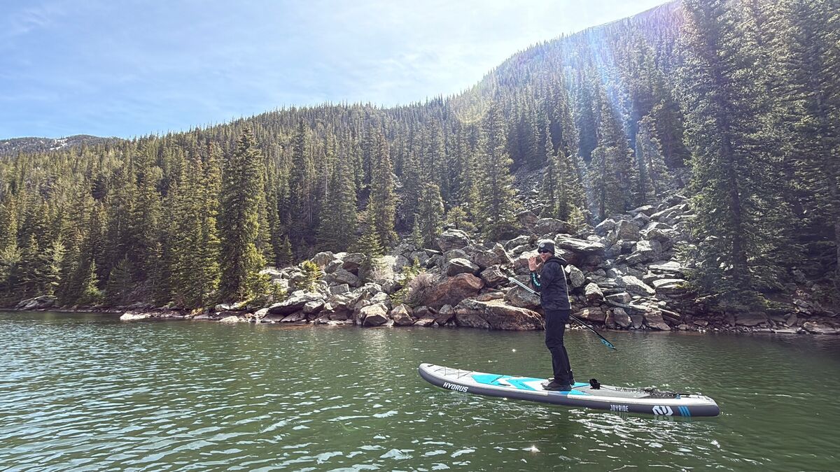 Person paddleboarding in the fall on river