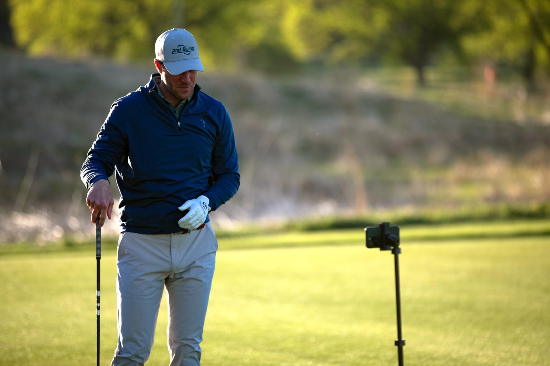 A golfer talking to a phone