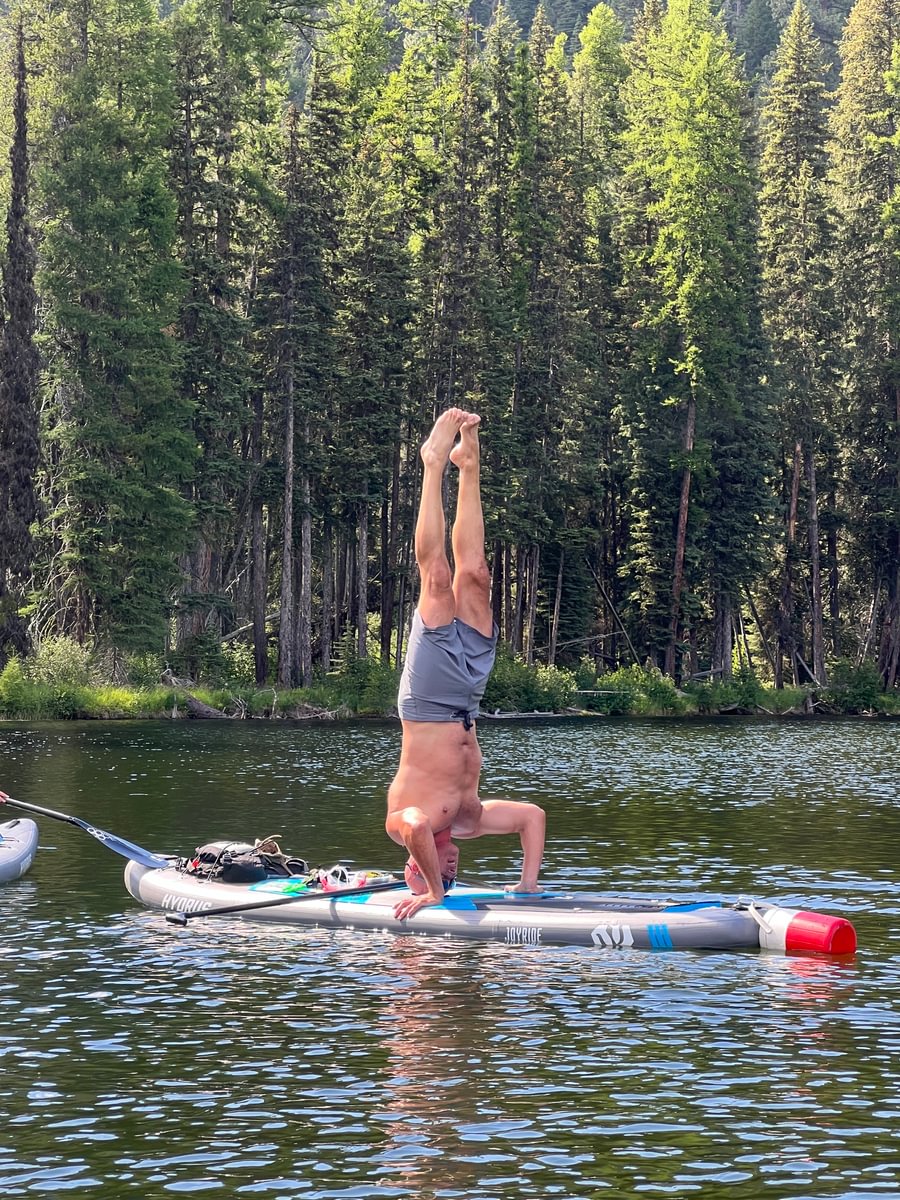 Man doing a headstand on paddleboard