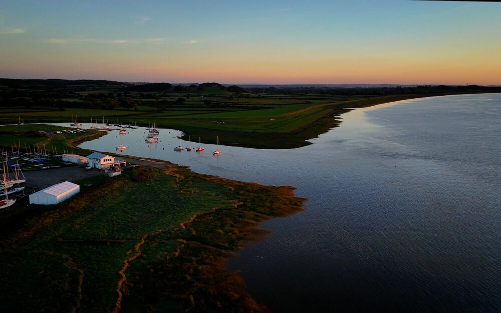 Drone shot of estuary and boats at sunset