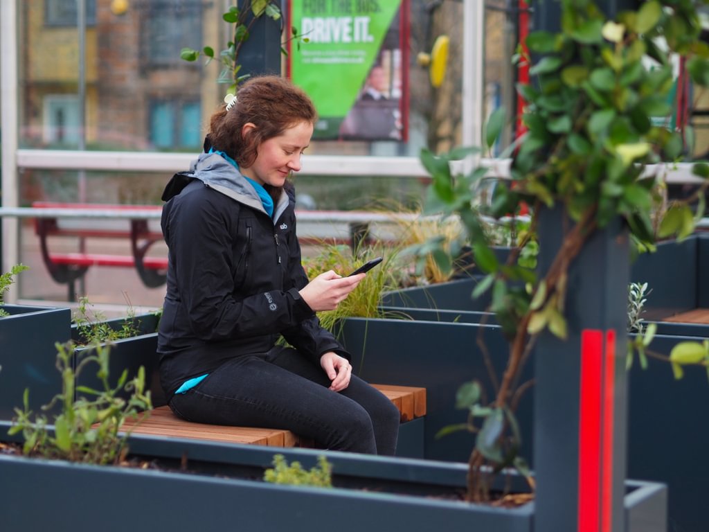 Person on phone at bus stop