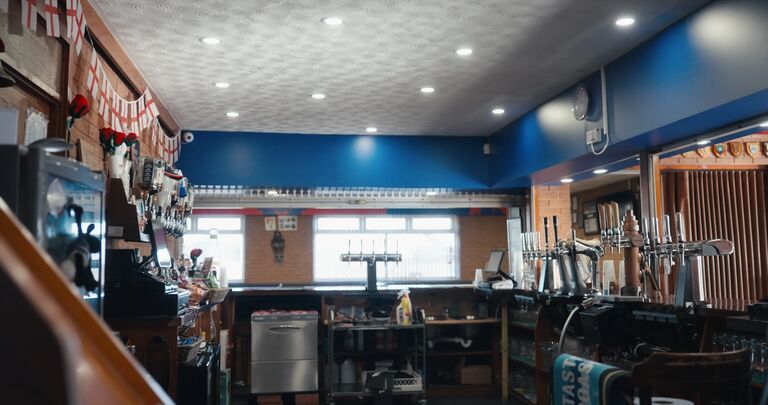 photo of interior of a bar, with blue walls and england flag bunting