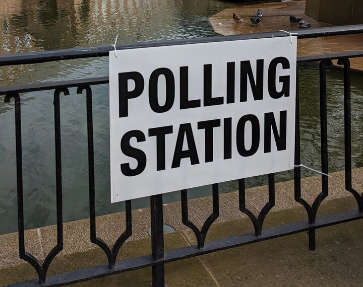 A 'polling station' sign is pictured on railings.