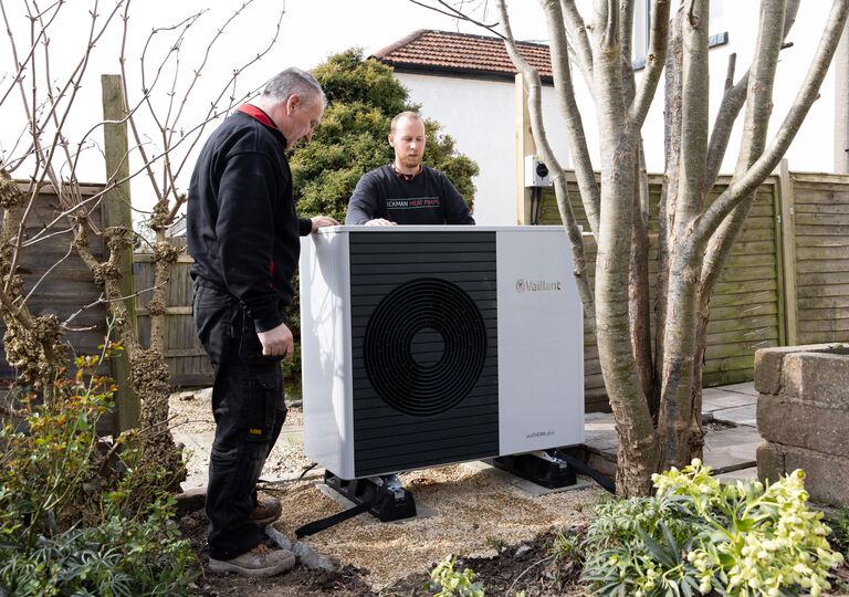 people standing around a heat pump