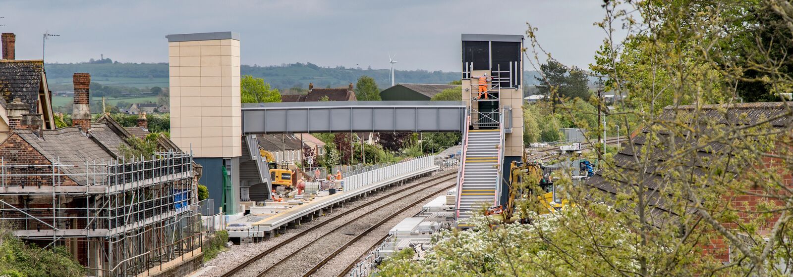 workers in high vis on the footbridge at the new charfield station in south gloucestershire