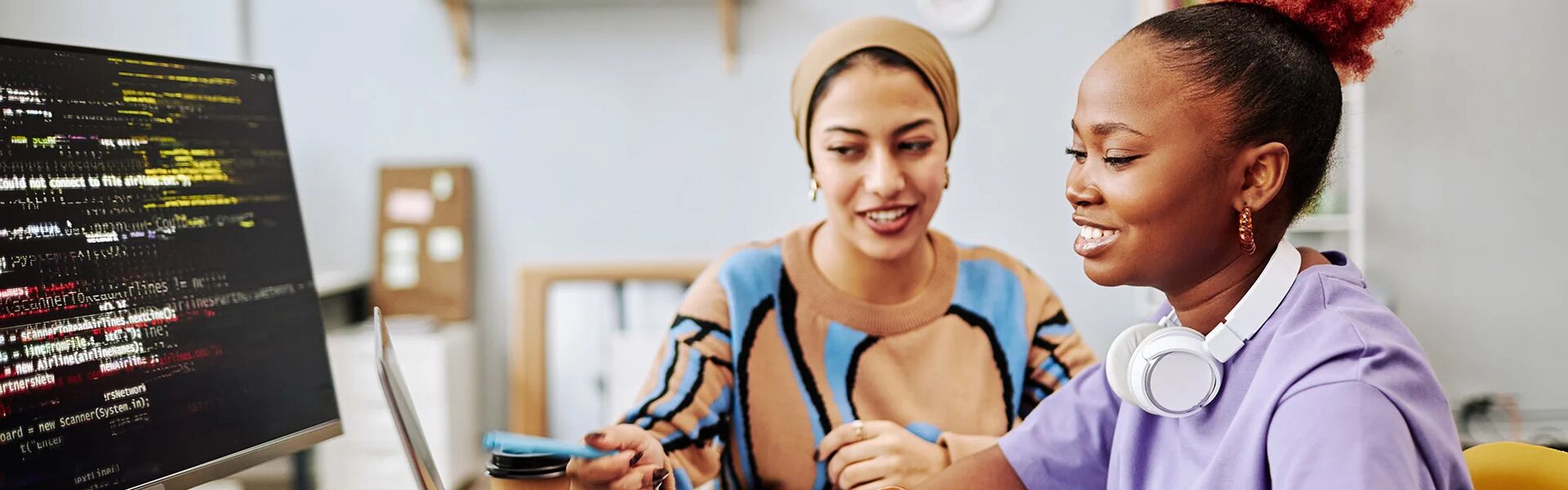 a young person on a laptop being supported by a mentor