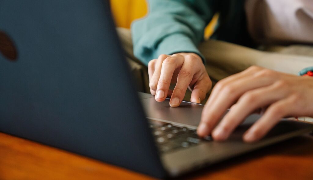 close up of hands on a laptop keyboard