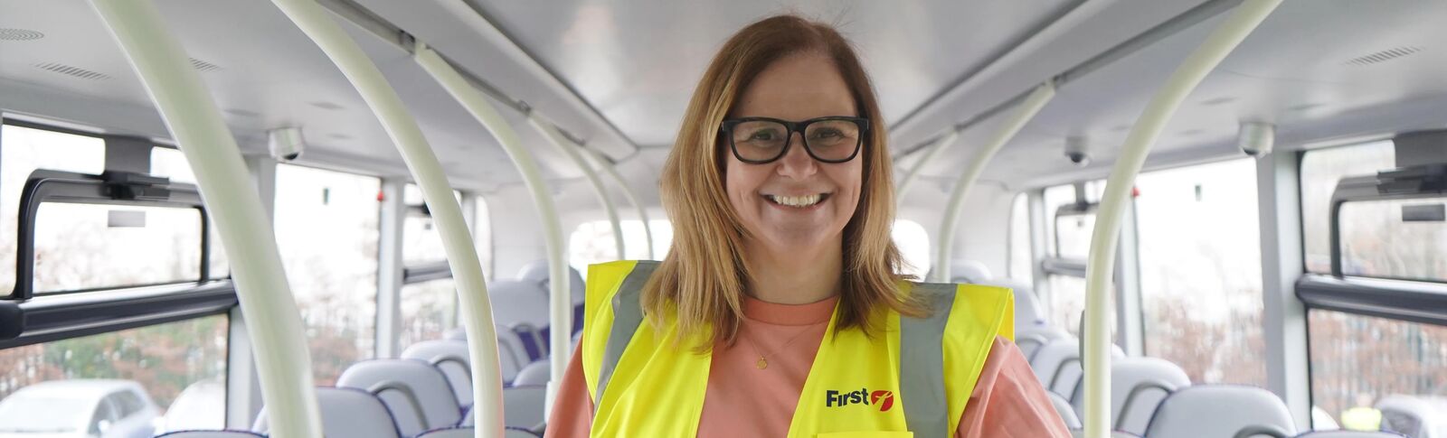 Mayor Helen Godwin on the top deck of a bus, wearing a first bus high-vis
