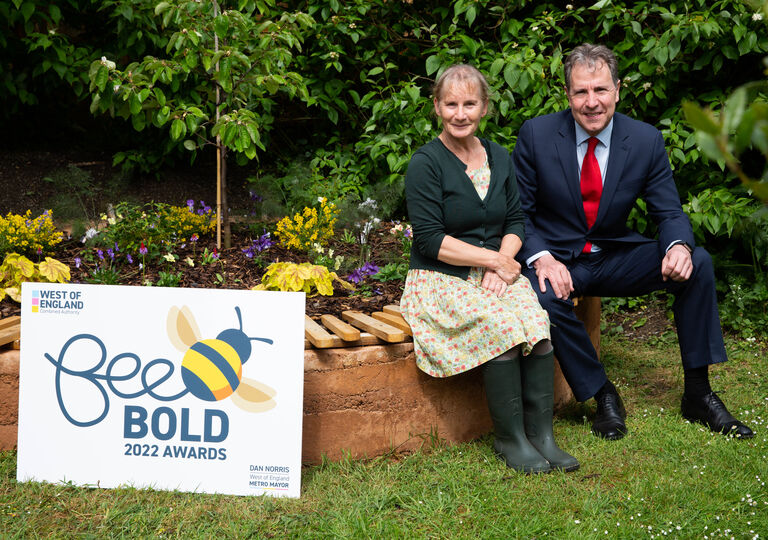 Susie Hewson, from Natracare, with Metro Mayor Dan Norris in a pollinator garden with the Bee Bold Day Awards sign