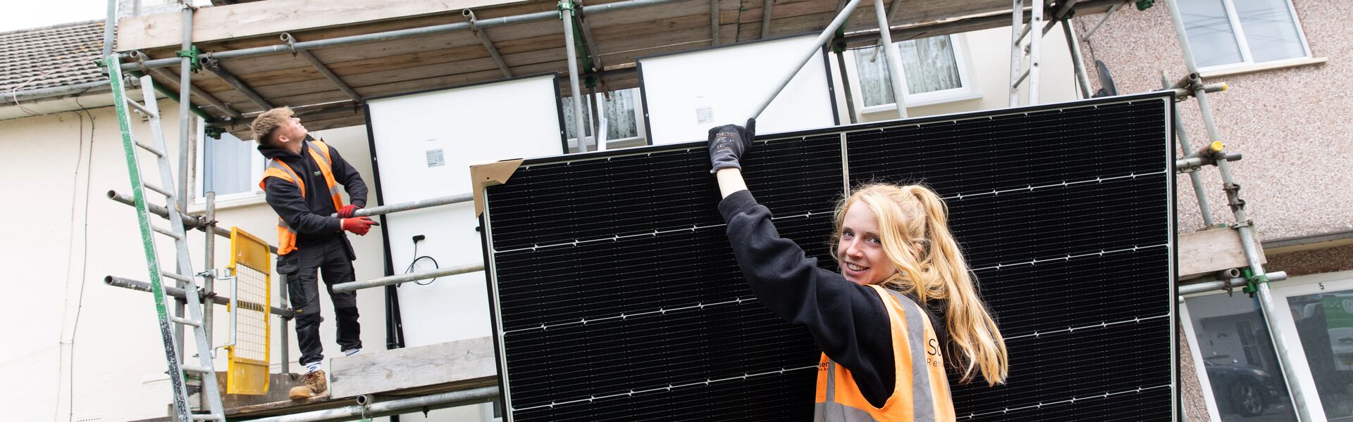 Person holding a solar panel on construction site