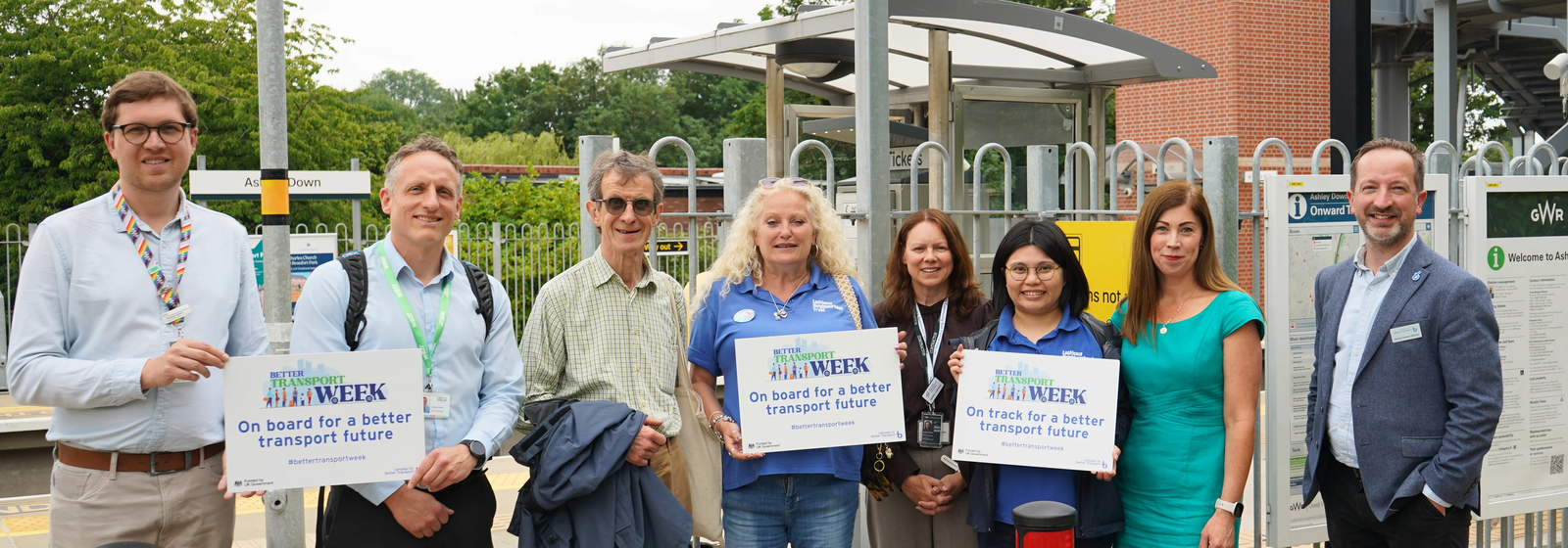 Representatives from the West of England's Transport network stand in a row at Ashley Down Station. They are all smiling at the camera