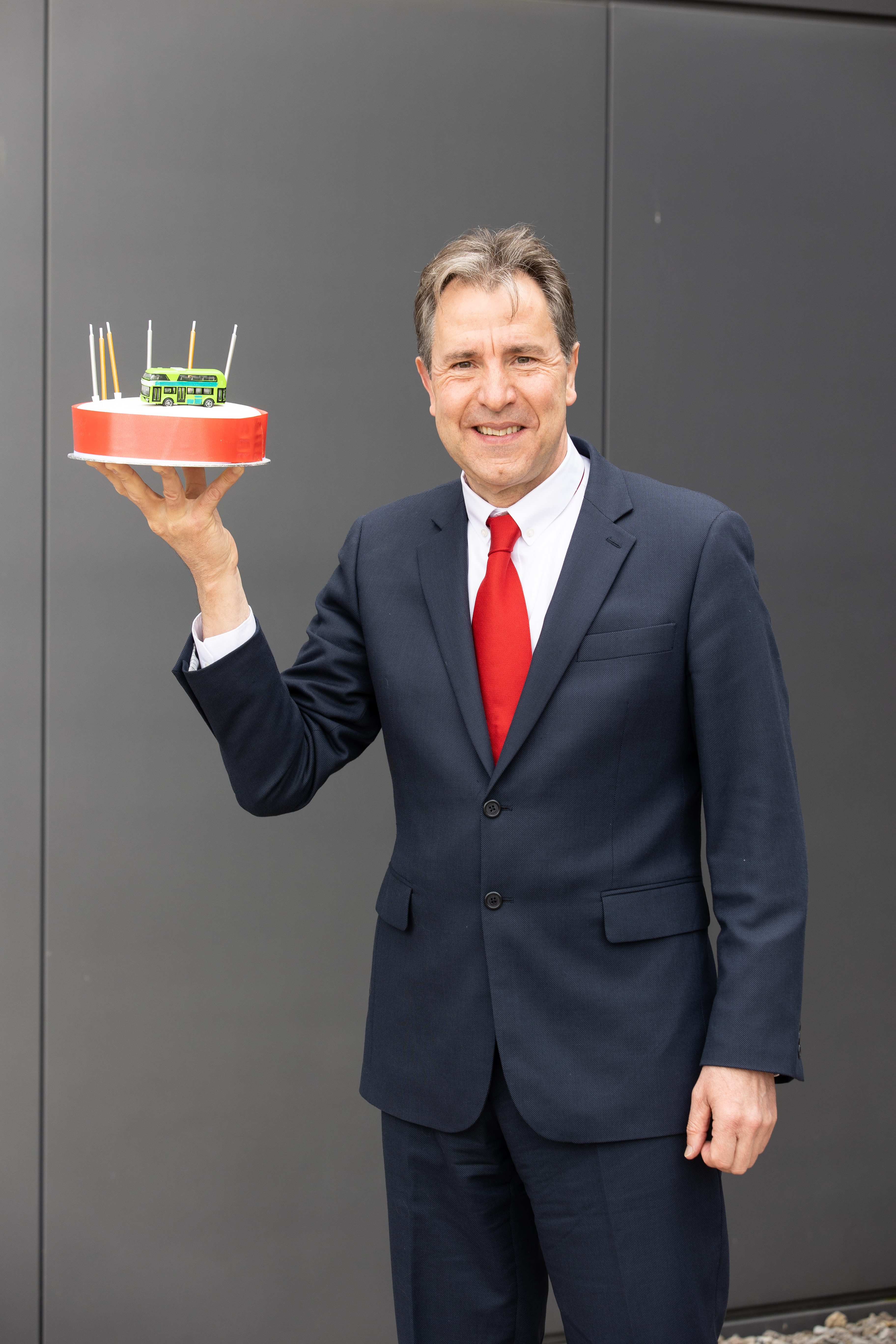 Dan Norris, metro mayor, holding a bus cake