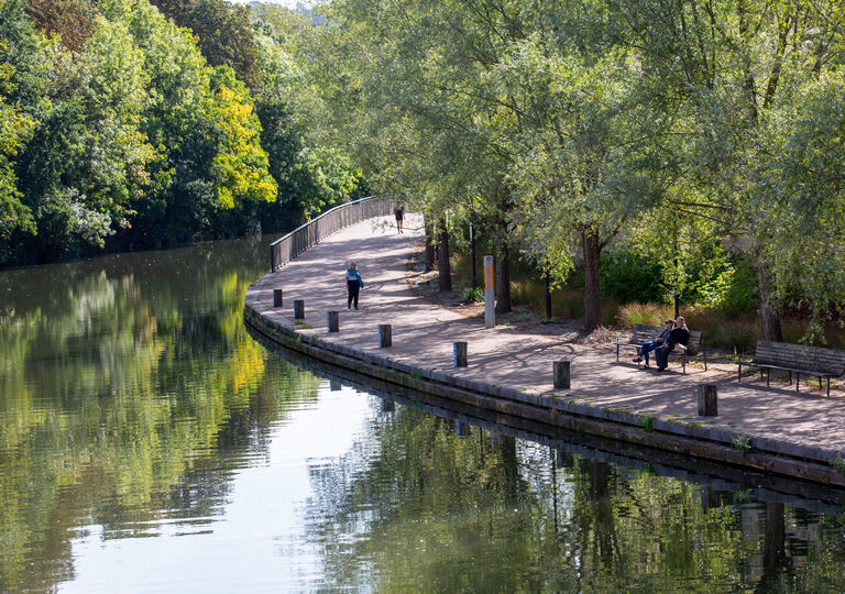 a person walking next to the river avon