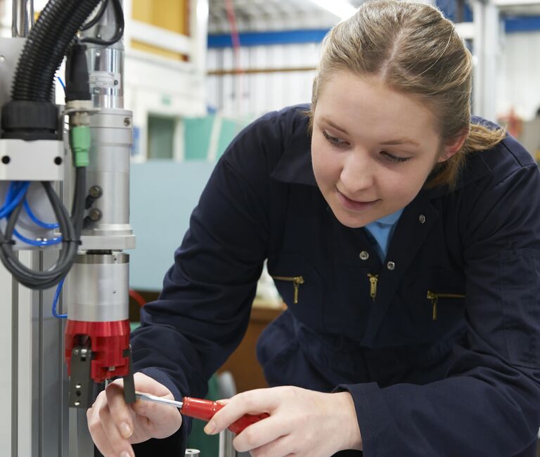 Smiling person working on a machine