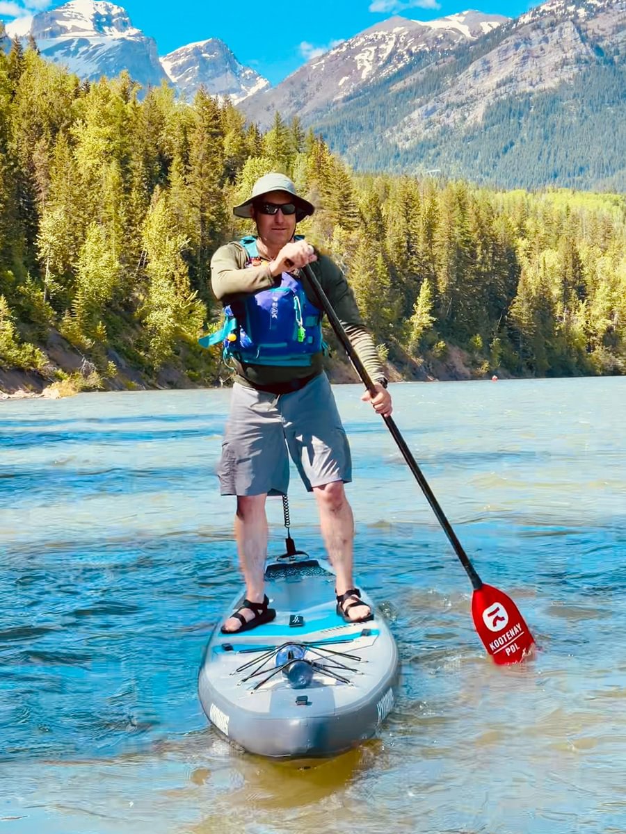 man paddling with life vest on a paddleboard
