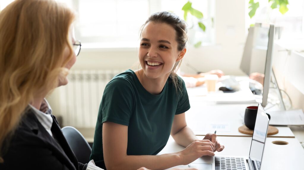 2 people smiling working together
