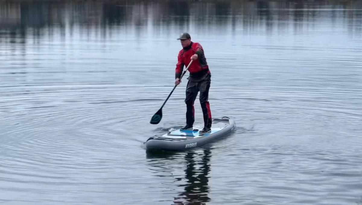 man paddleboarding in drysuit in cold water