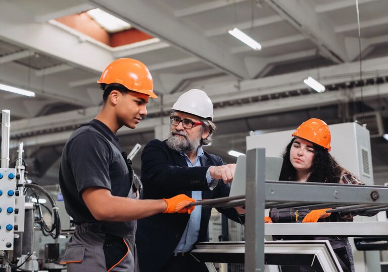 two young workers in construction with mentor