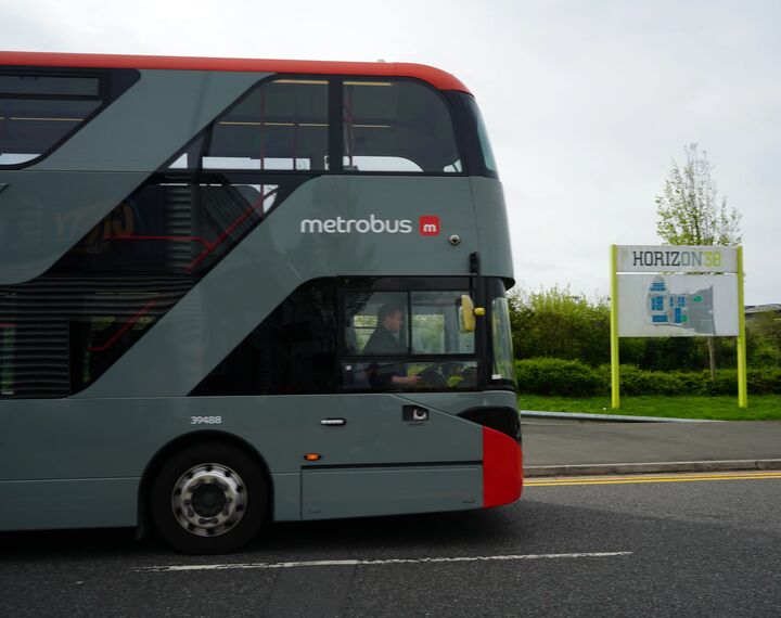 grey bus driving down road