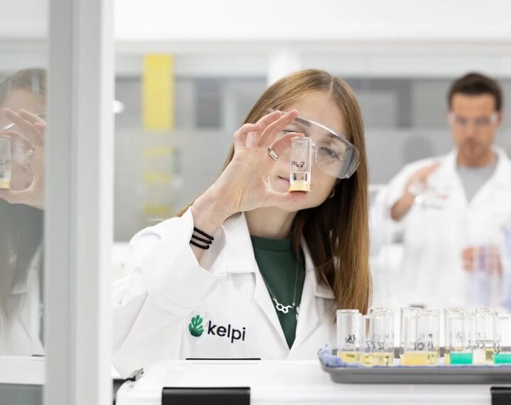 A woman looking at a small bottle she's holding