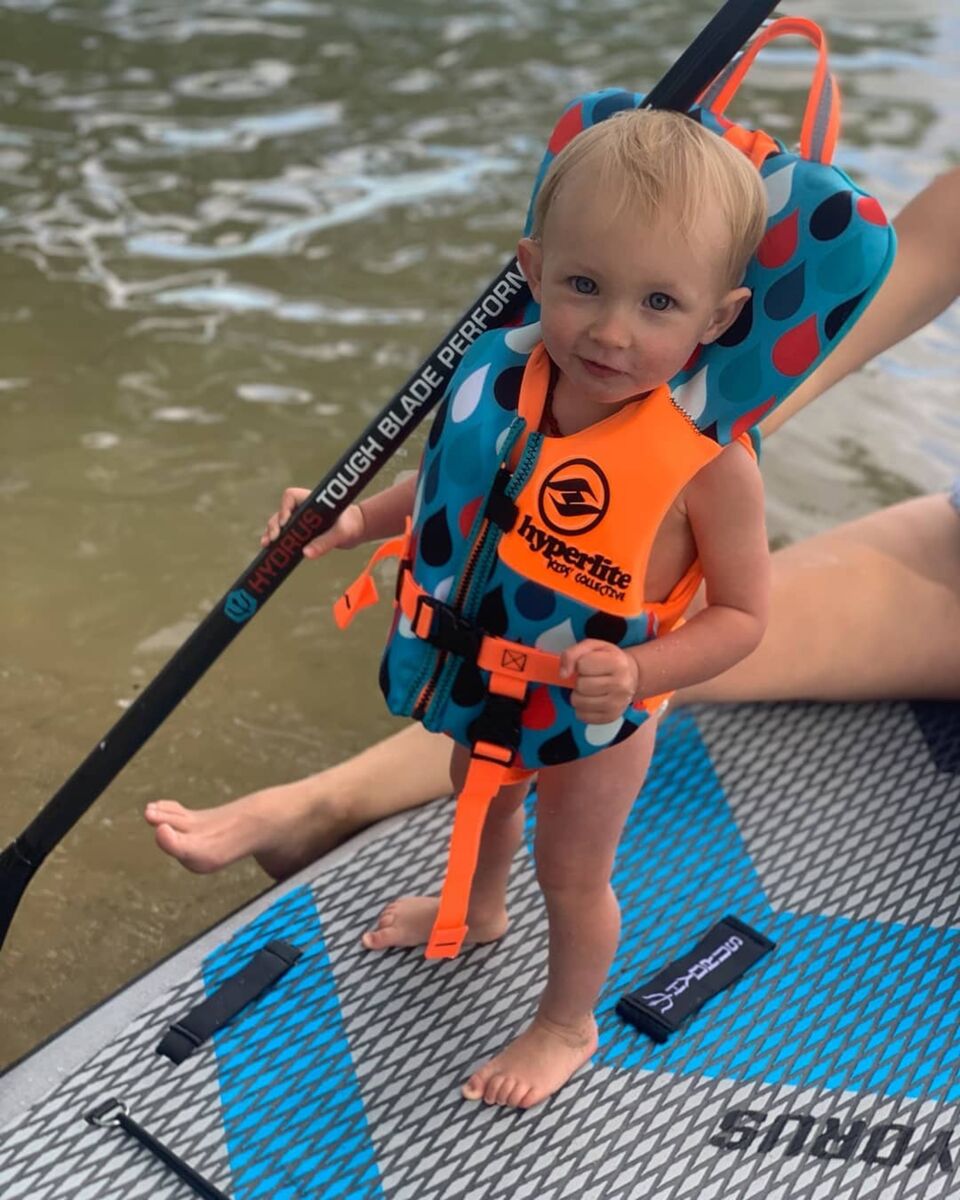 kid in life jacket on paddleboard
