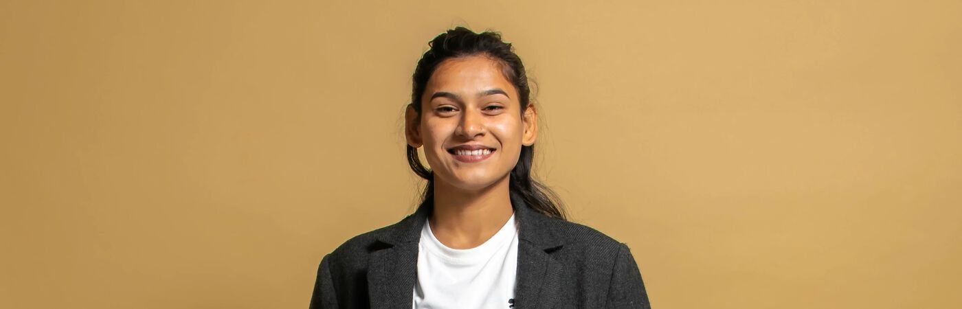 Young person smiling in a blazer