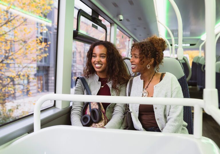 two young women sitting on a bus
